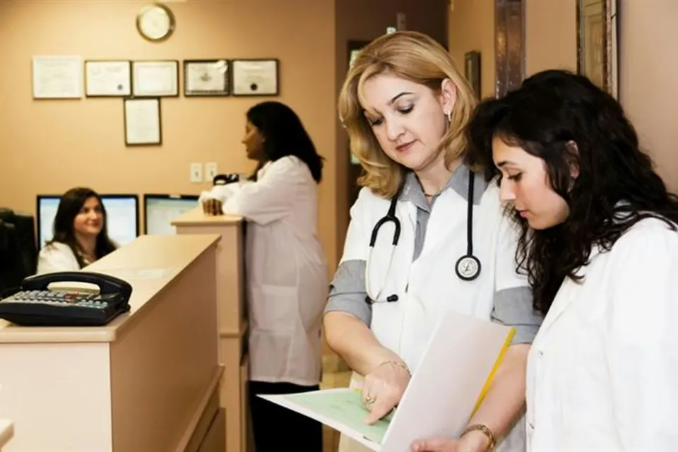 Clinic staff reviewing a patient file at reception